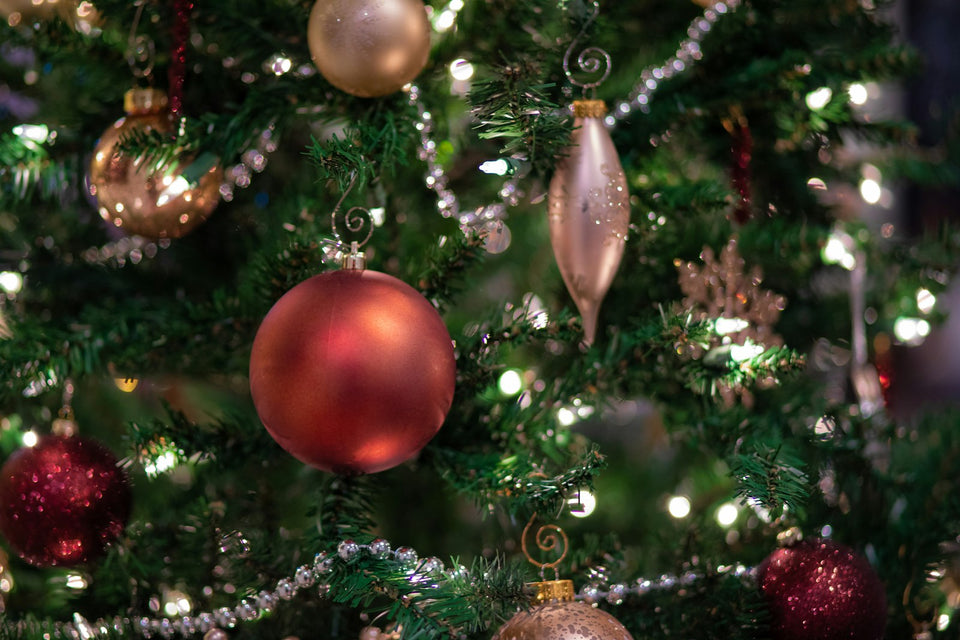 Unique Christmas ornaments hanging on a lit Christmas tree