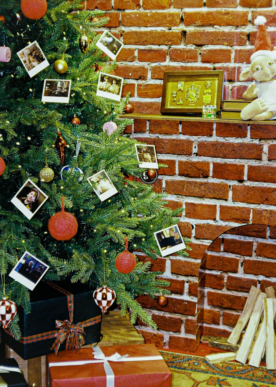 Photo Christmas ornaments and family pictures hanging on a Christmas tree beside a brick wall