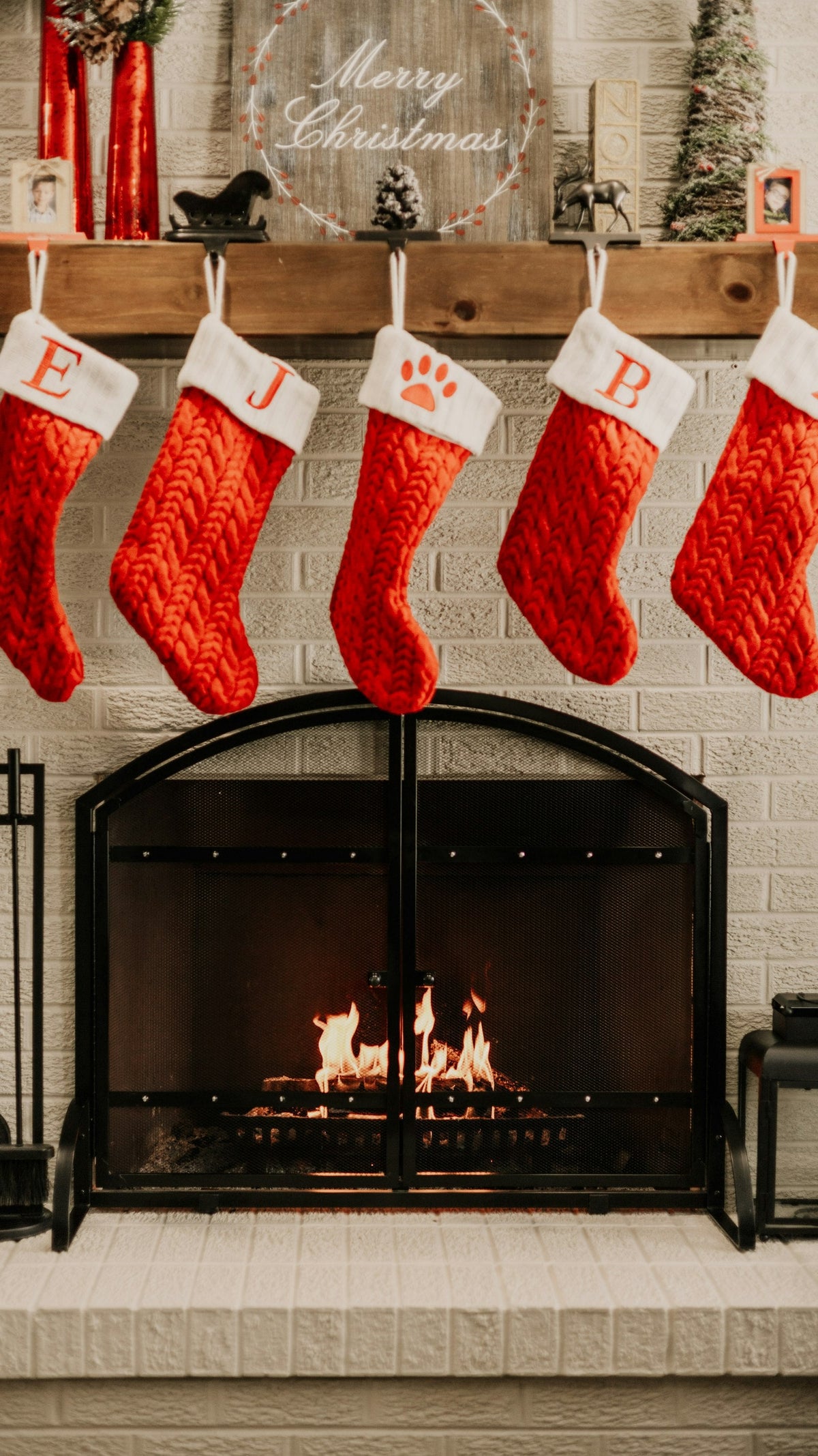 Christmas stockings hanging over a cozy fireplace, ready for stocking stuffers for husband