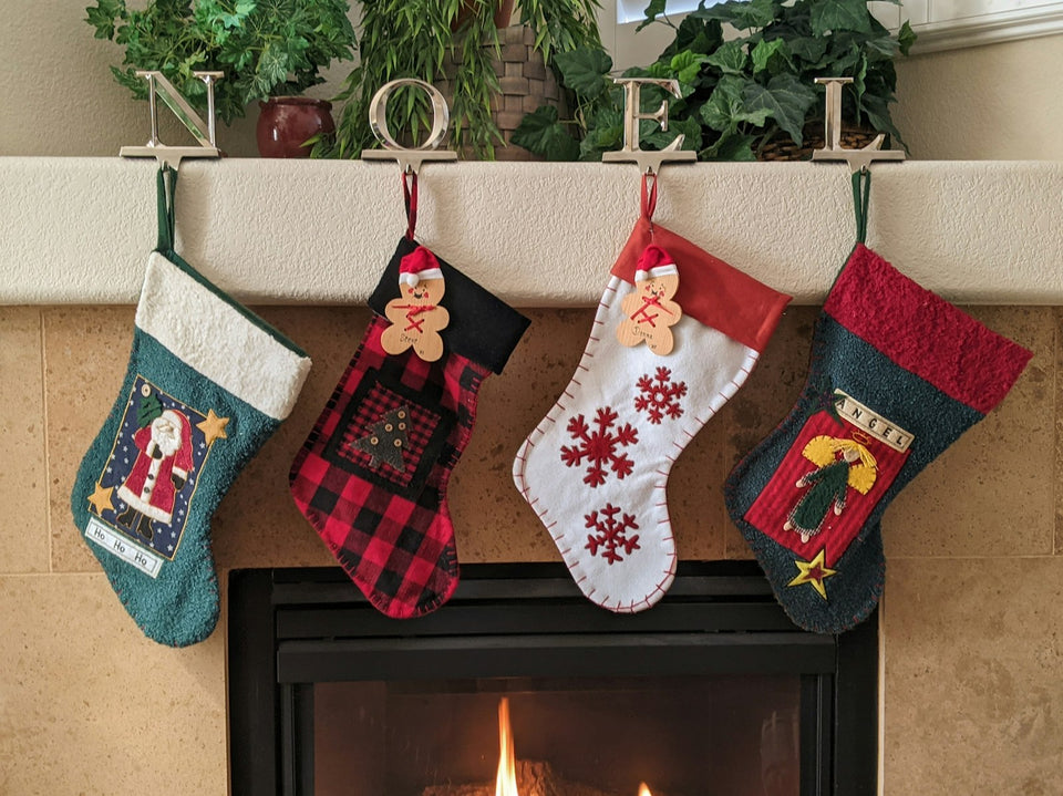 Red and white Christmas stockings hanging over a fireplace, ready for stocking stuffers for men