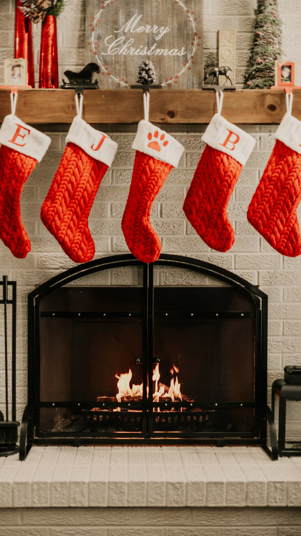 Christmas stockings hanging over a cozy fireplace, ready for stocking stuffers for husband